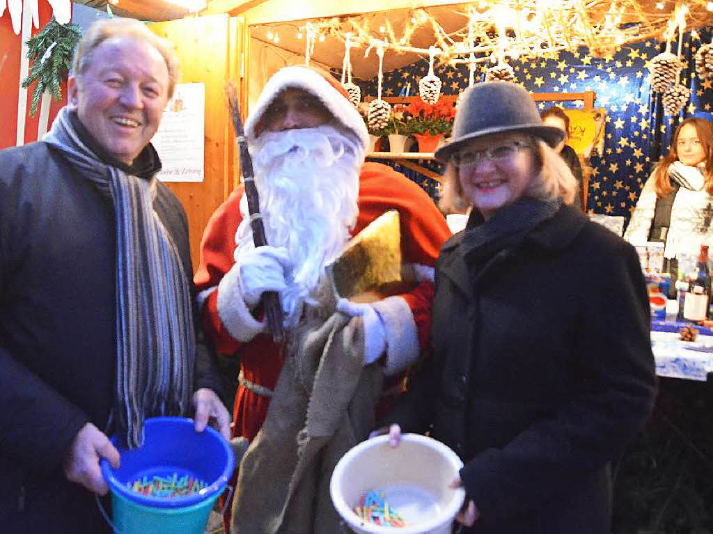 Der Nikolaus zeigt Paul Renz und Sabine hartmann-Mller beim Losverkauf Goldenes Buche und Rute.