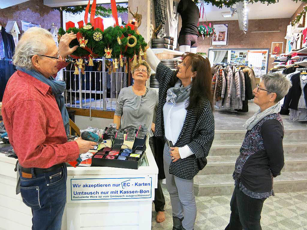 Im Modehaus Nehmer zndet man gemeinsam  den Adventskranz an.