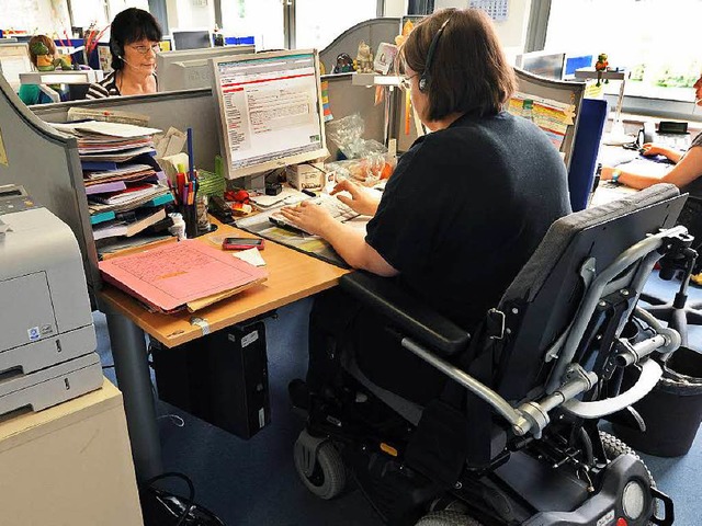 Eine Frau im Rollstuhl arbeitet in ein...erbehinderte Menschen nicht erfllen.   | Foto: dpa