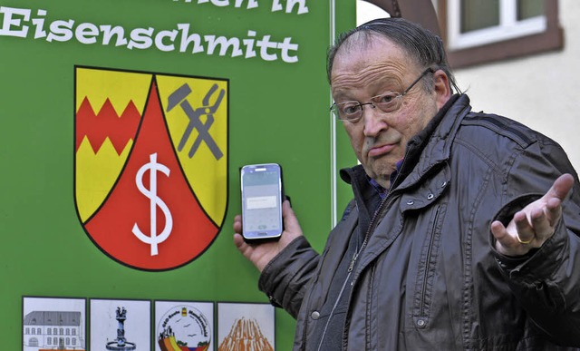 Brgermeister Fritzsche mit seinem Handy &#8211; im Ort leider nutzlos.   | Foto:  dpa