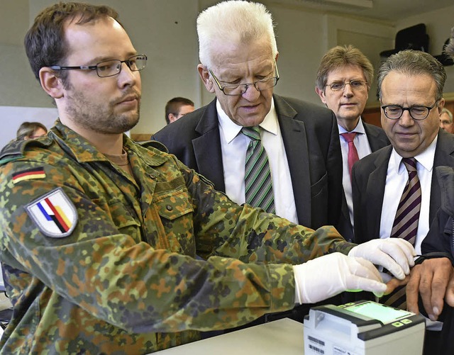 Amtschef  Weise (r.) und Politiker  Kretschmann (M.)  bei einer Registrierung   | Foto: dpa