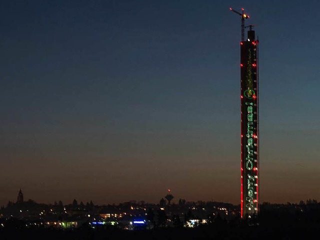 Weihnachtsgre in vielen Sprachen werden auf den Aufzug-Test-Turm projeziiert.  | Foto: dpa