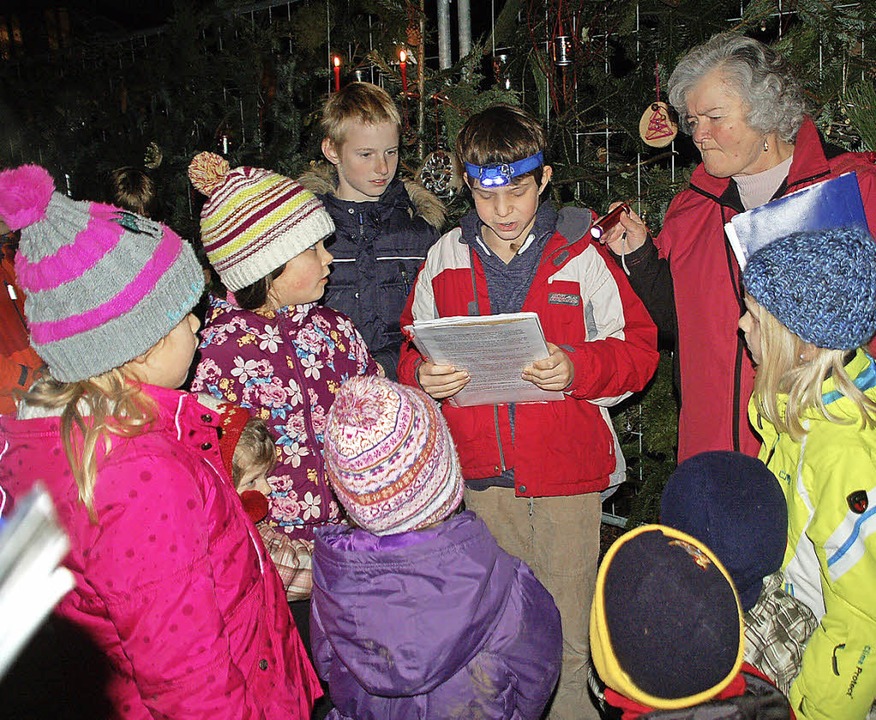Schulkinder lesen die Weihnachtsgeschi...in Ilse Moser (rechts) leuchtet dazu.   | Foto: Petra Wunderle