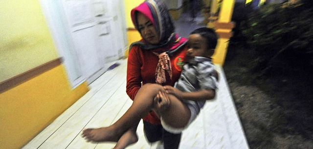 Eine Helferin trgt einen geretteten J...nes Krankenhauses im Sden Sulawesis.   | Foto: dpa