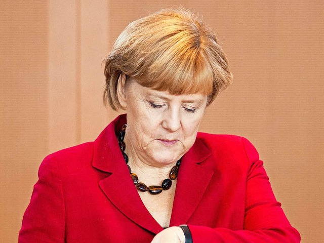 Bundeskanzlerin Angela Merkel (CDU) schaut auf die Uhr  | Foto: Kay Nietfeld