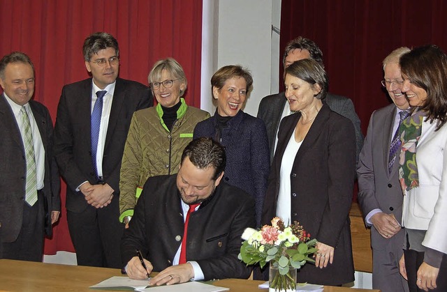 Minister Alexander Bonde unterzeichnet... danach die Fahne des neuen Gebietes.   | Foto: Claudia Renk