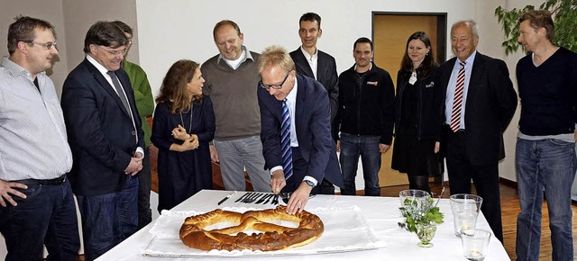 Vertreter der Vereine und des Gemeinde...spannt das erste Stck Neujahrsbrezel.  | Foto: Julius Wilhelm Steckmeister