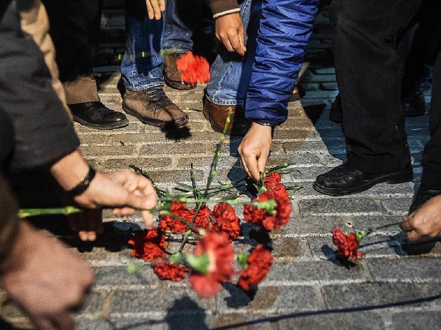 Menschen gedenken der Opfer.   | Foto: AFP