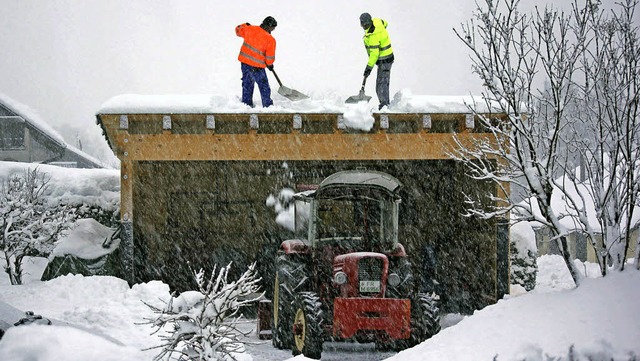 Einwohner schippen in Eisenbach die zu schwere Schneelast von einem Dach.   | Foto: Gerd Brichta