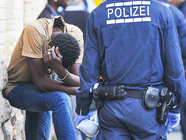 Ein Polizist berwacht in Mannheim  vo...le fr Flchtlinge einen Verdchtigen.  | Foto: dpa