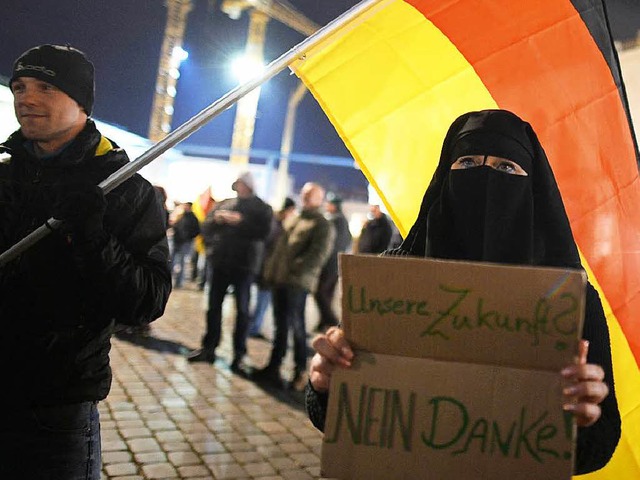 Eine Frau demonstriert whrend einer Pegida-Kundgebung in Dresden.  | Foto: dpa