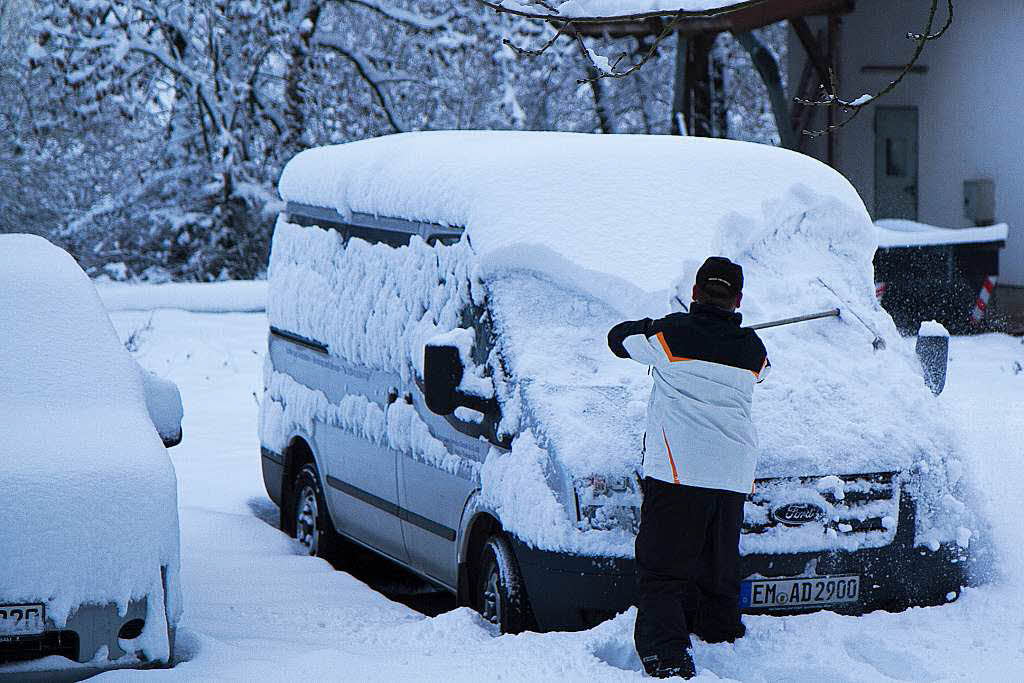 Autos werden in Oberwinden am Sonntag morgen vom Schnee befreit.