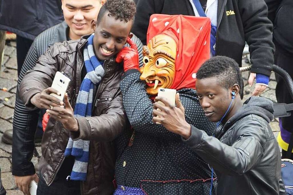 Selfie mit Offenburger Hexe: Die jungen Flüchtlinge Syedali aus Somalia (l.) und Osman aus dem Senegal haben Spaß an der Offenburger Fasent: „It’s fun!“ – es ist ein Spaß. (Foto: Helmut Seller) Selfie mit Offenburger Hexe: Die jungen Flüchtlinge Syedali aus Somalia (l.) und Osman aus dem Senegal haben Spaß an der Offenburger Fasent: „It’s fun!“ – es ist ein Spaß. (Foto: Helmut Seller)