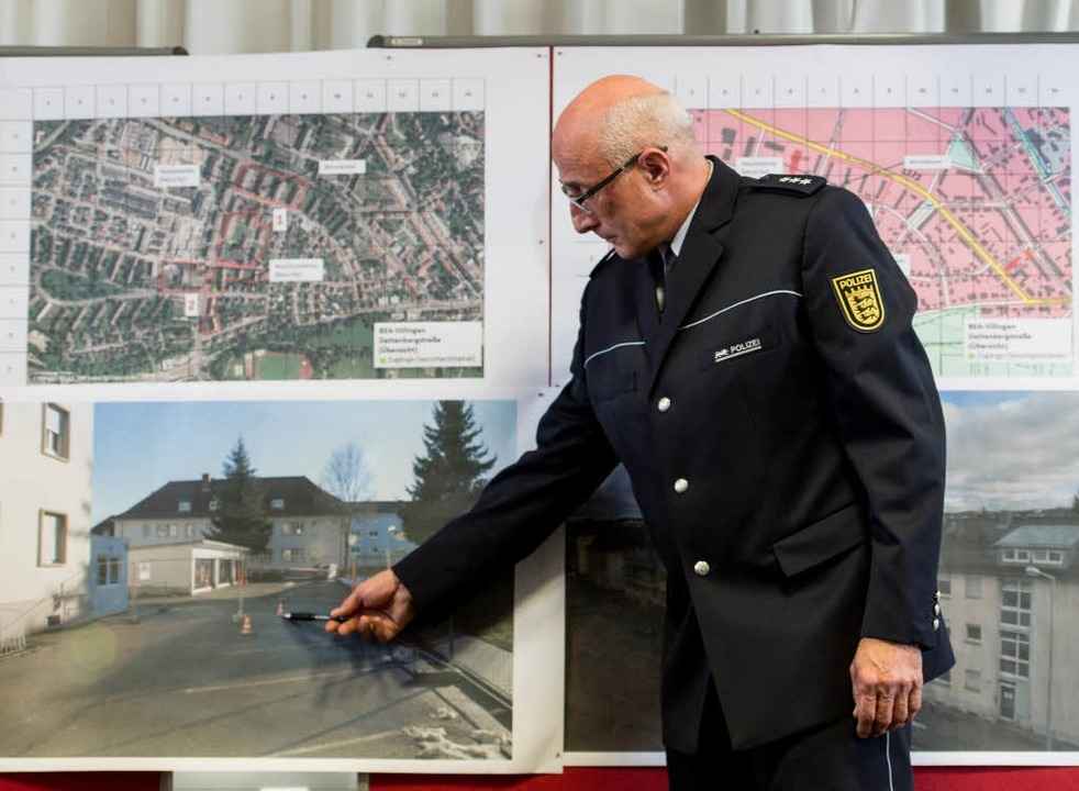 Polizeisprecher  Sebold zeigt  auf ein...on der Container der Sicherheitsleute.  | Foto: dpa