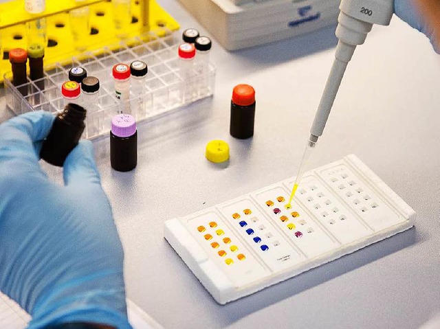 Eine Labormitarbeiterin untersucht am ...uorenztest eine Probe mit Antikrpern.  | Foto: dpa