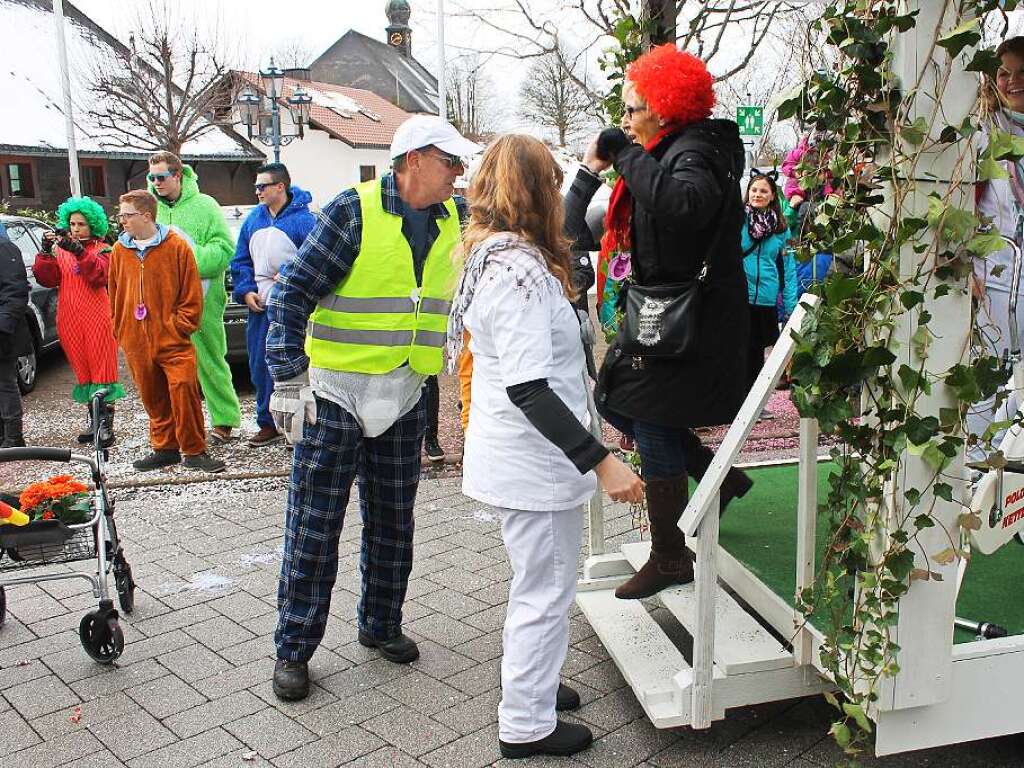 Galant: ein Herr in Windeln hilft einer Dame aus dem Publikum die Stufen des Wagens „Tagespflege St. Fridle“ hinunter.