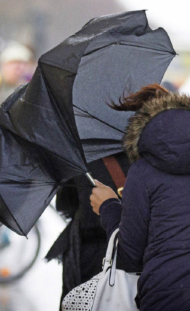 Eine Passantin mit Schirm kmpft bei e...ngenen November mit Sturm und Regen.    | Foto: Kay Nietfeld/DPA