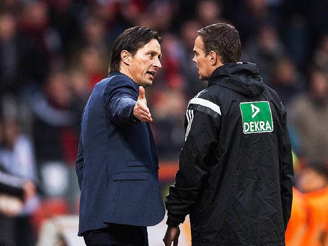 Leverkusens Trainer Roger Schmidt (l) ...erten Offiziellen Christoph Bornhorst.  | Foto: dpa
