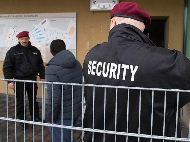 Security-Leute bewachen eine Flchtlingsunterkunft in Ellwangen.  | Foto: dpa