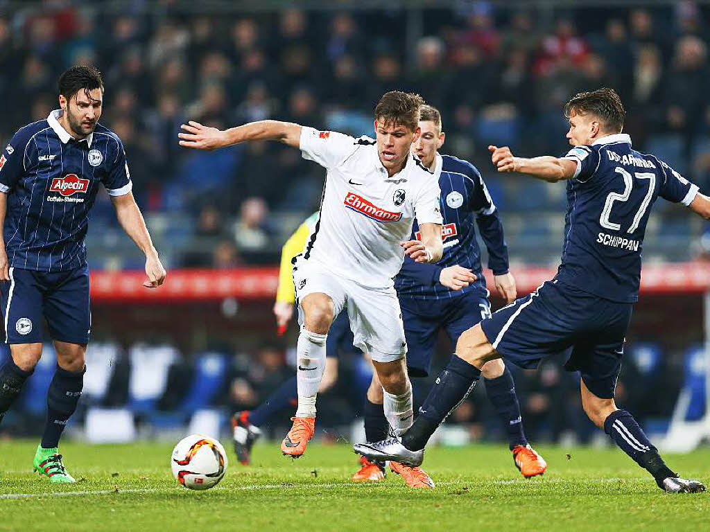 Bielefelds Stephan Salger (l) und Sebastian Schuppan (r) im Kampf um den Ball mit Florian Niederlechner.