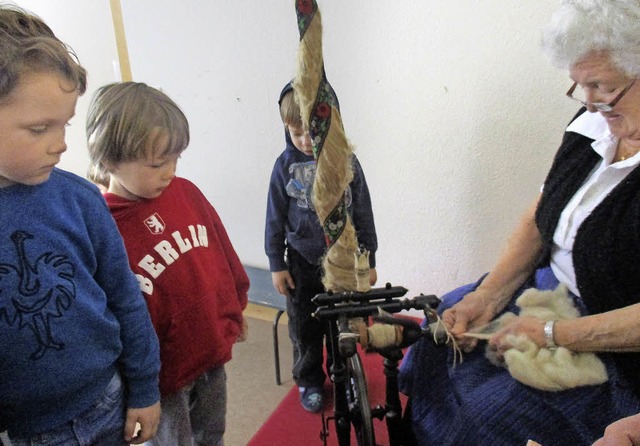 Annemarie Spitz zeigt den sehr interes... wie man mit einem Spinnrad arbeitet.   | Foto: Kindergarten St. Franziskus