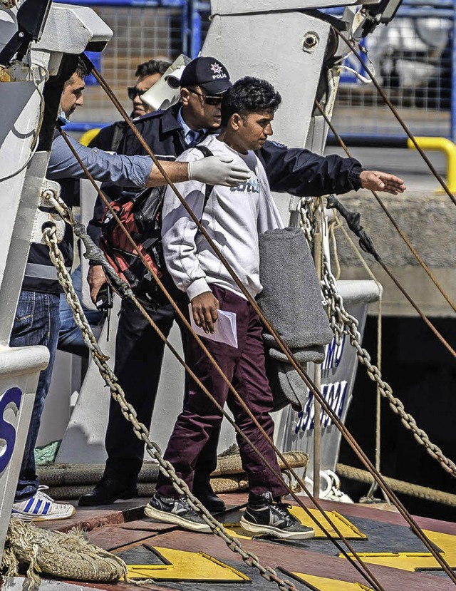 Sicherheitsleute weisen einem  Migrant...de im trkischen Dikili das  Schiff.    | Foto: AFP