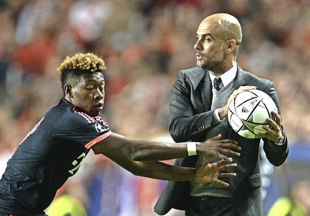 Als wollte er mitspielen: Bayern-Coach...la schnappt David Alaba den Ball weg.   | Foto: dpa