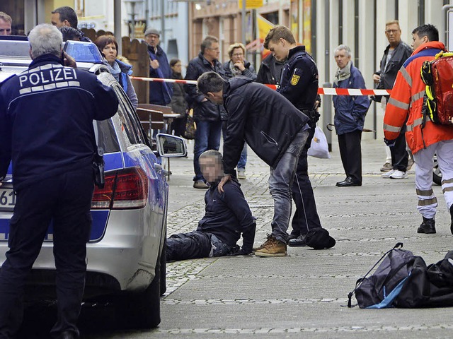 Einer der mutmalichen Tter wird von Polizeibeamten festgehalten.  | Foto: Ralf Burgmaier