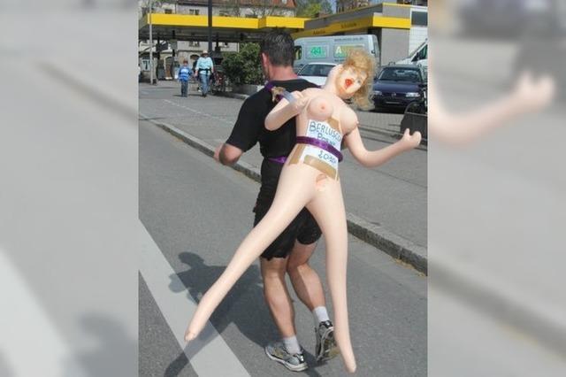 Warum läuft dieser Mann den Freiburg-Marathon mit einer Gummipuppe auf dem Rücken?