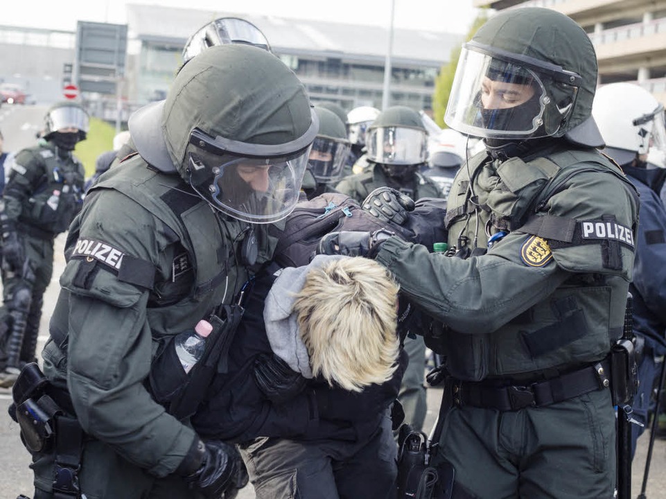 Polizisten transportieren einen Demonstranten ab.  | Foto: dpa