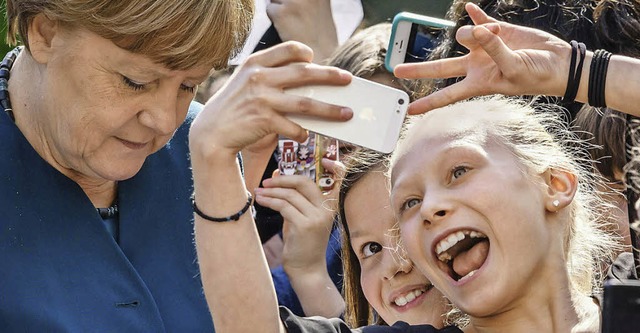Angesagt: Selfie mit der Kanzlerin   | Foto: AFP