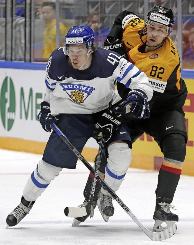 Der Deutsche Sinan Akdag (rechts) vers...Antti Pihlstrom den Puck abzuluchsen.   | Foto: dpa