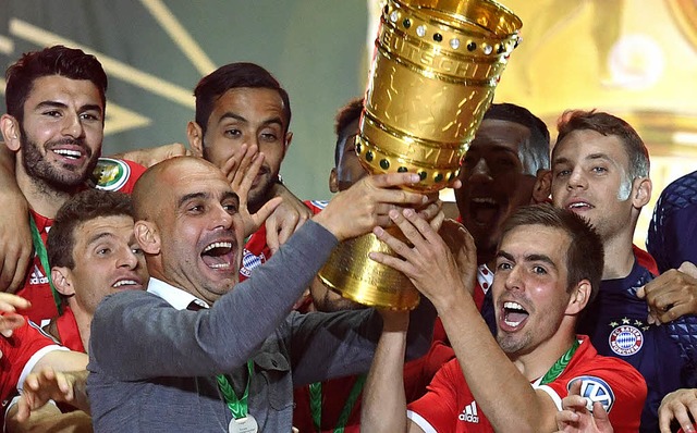 Handarbeit:    Guardiola (links)  und Philipp Lahm strahlen mit Cup.     | Foto: dpa