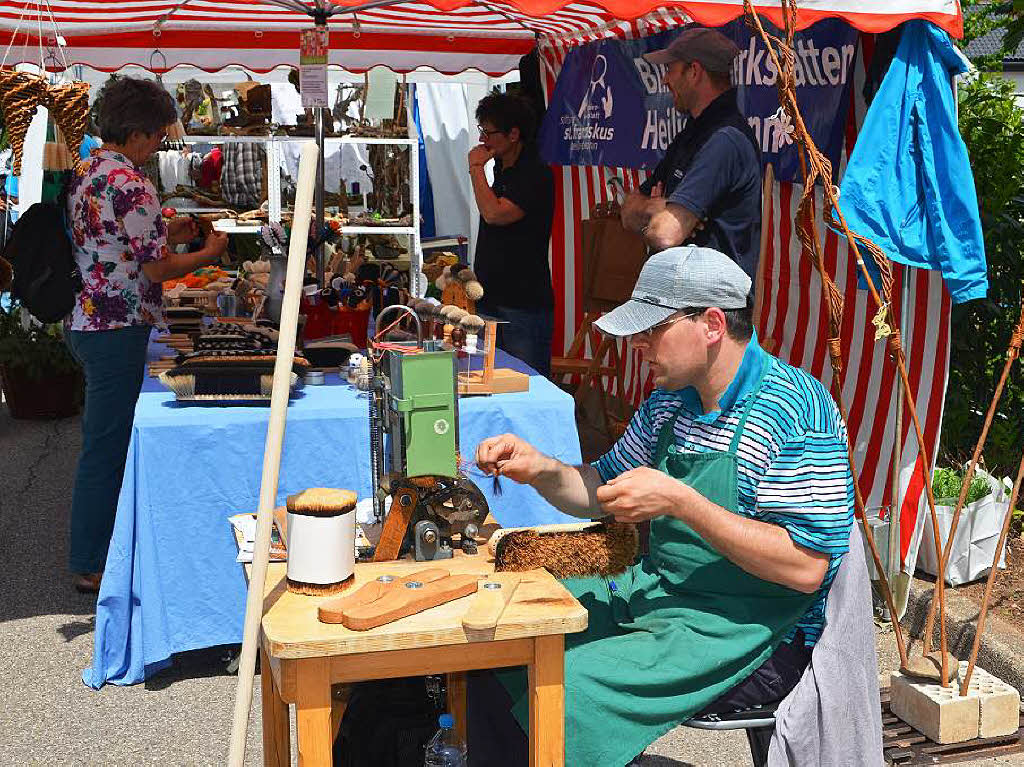 Traditionelles Handwerk war auch vertreten: Ein sehbehinderter Mann zeigte mit  viel Fertigkeit und Einbeziehung der kleinen Maschine die Arbeit des Besenbinders.