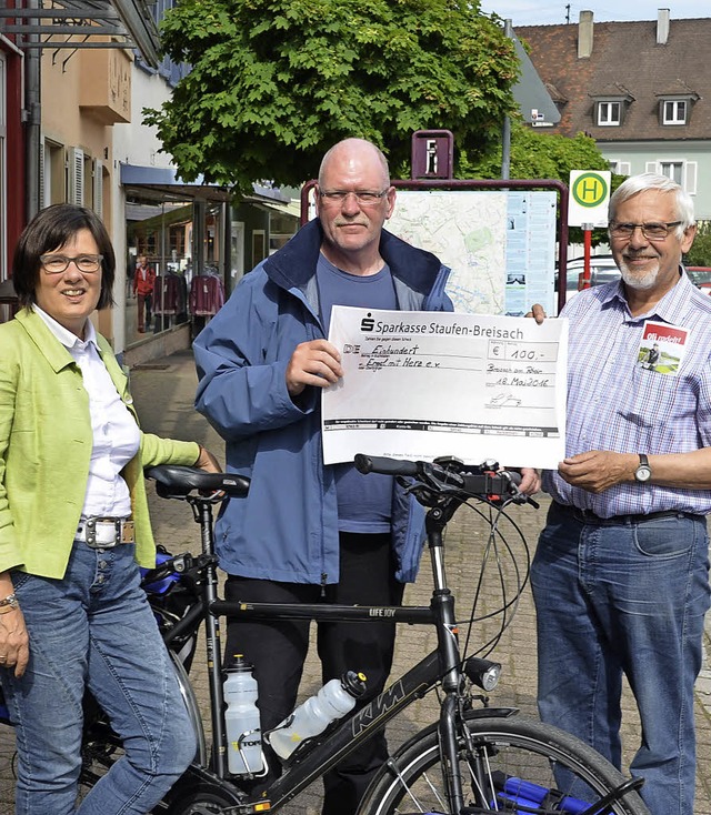 Oli Trelenberg (Bildmitte) radelt fr ...n ihm einen Scheck der Stadt Breisach.  | Foto: Voigt