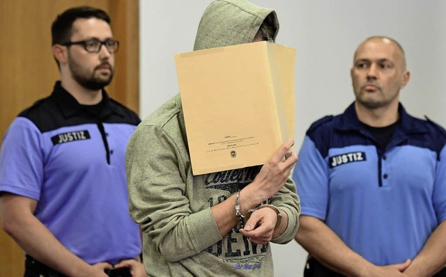 Silvio S. verdeckt sein Gesicht beim Gang auf die Anklagebank.   | Foto: dpa
