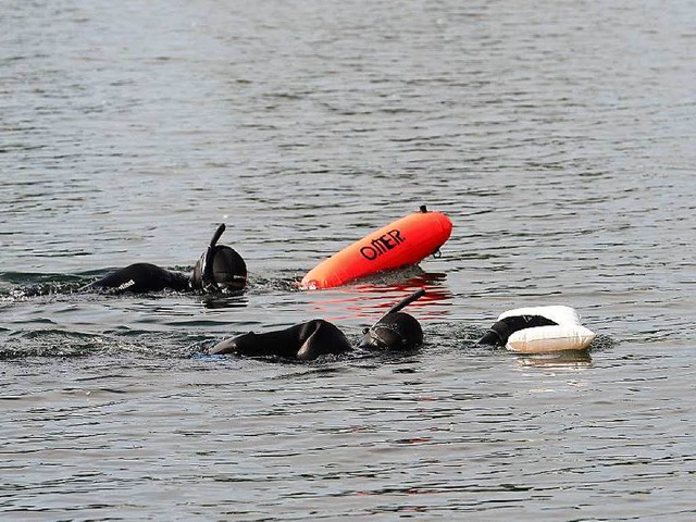 Zwei Sicherungsschwimmer schnorcheln neben Grabs her.  | Foto: Ingo Schneider