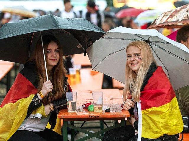 Mit Schirm und Deutschlandfahne: Public Viewing im Regen auf der Messe Freiburg  | Foto: dpa