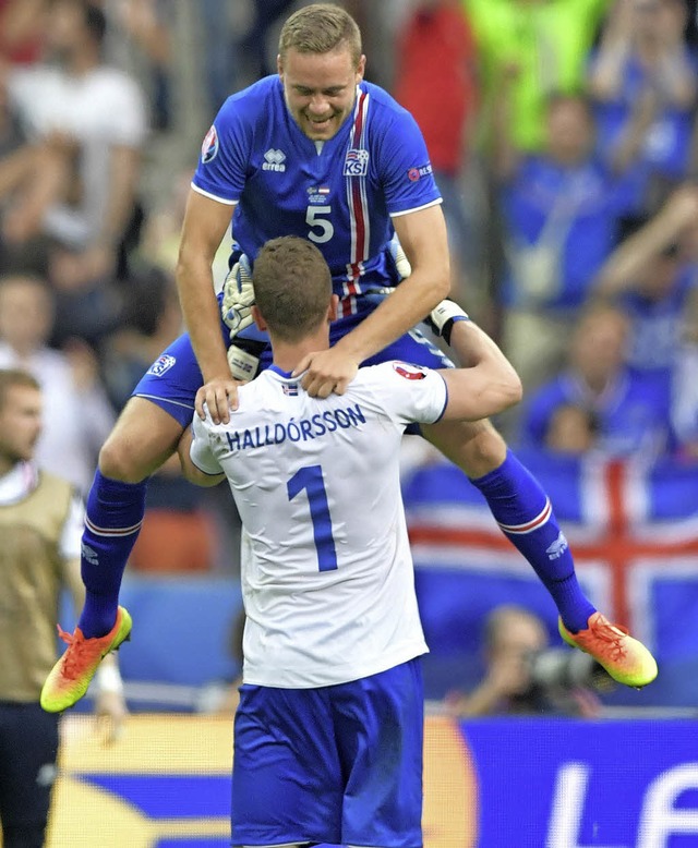 Torwart  Hannes  Halldorsson und  Sver...on feiern den  Sieg gegen sterreich.   | Foto:  DPA