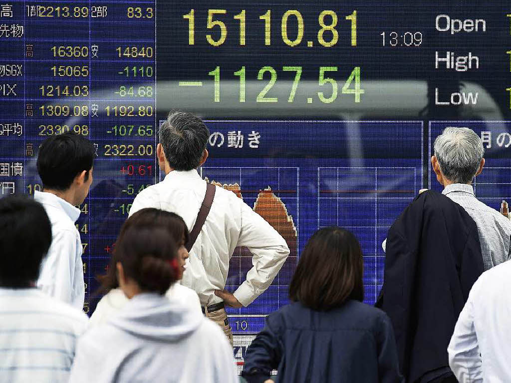 Die Finanzmrkte reagieren weltweit stark. Hier beobachten Brsianer in Tokyo die Kursentwicklung. Auch der Dax ist eingebrochen.