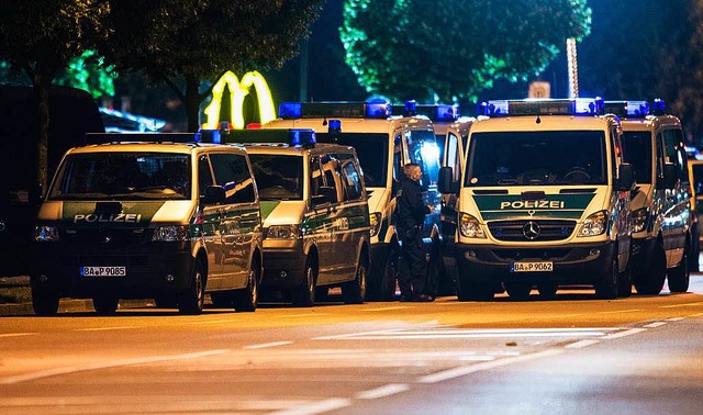 Polizeifahrzeuge vor dem McDonald&#821...Mnchen, in dem die Schieerei begann.  | Foto: dpa