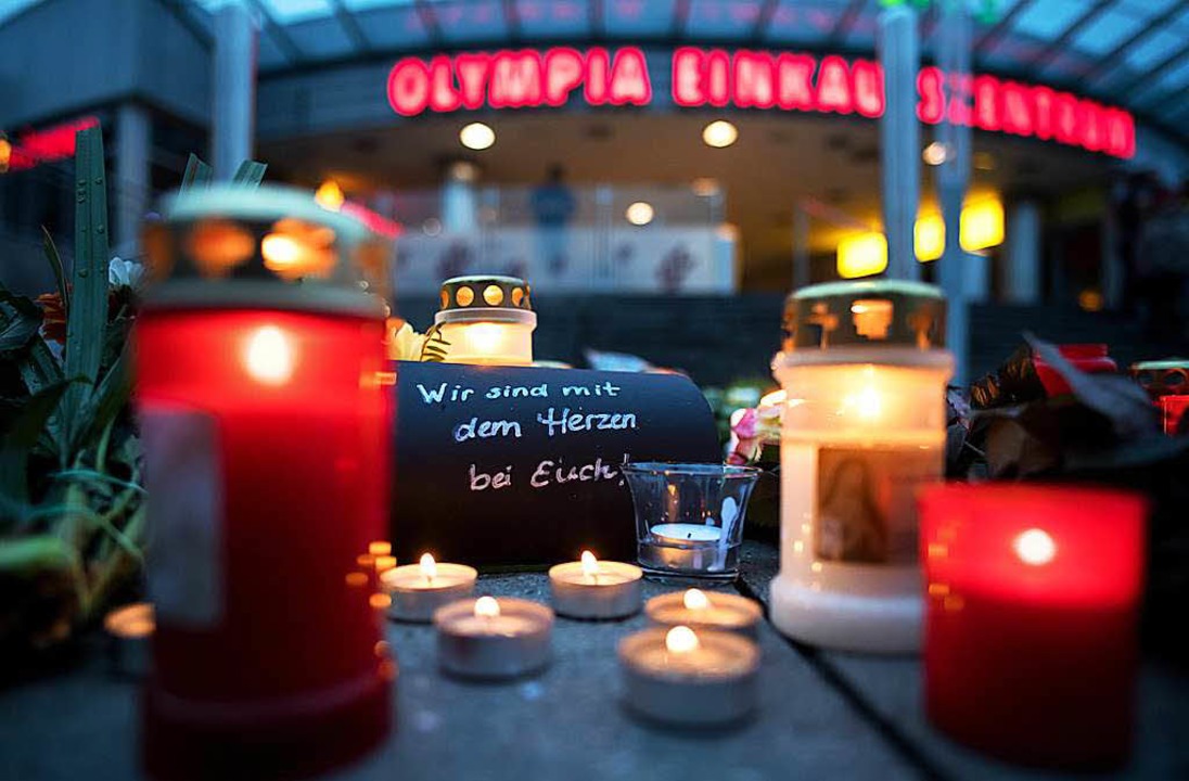 Vor dem Olympia-Einkaufszentrum stehen...m Gedenken an die Opfer des Amoklaufs.  | Foto: dpa