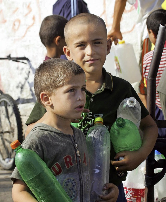 Kinder holen fr ihre Familien Wasser.  | Foto: afp
