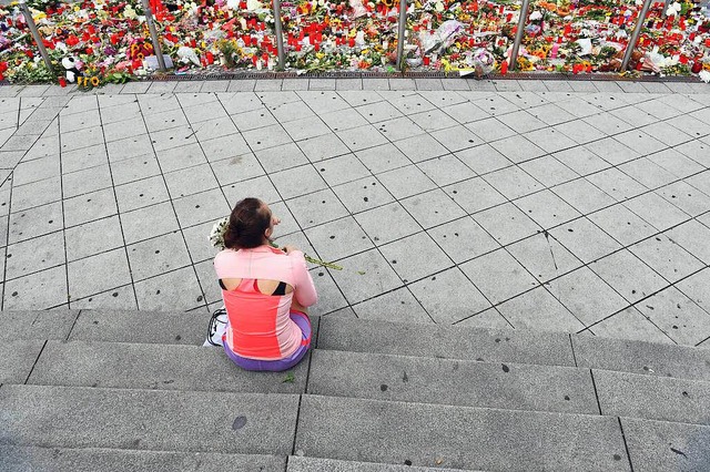 Trauer in Mnchen: Eine junge Frau sit... der Opfer des Amoklaufs gedacht wird.  | Foto: dpa