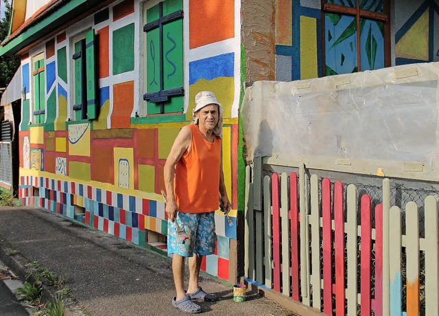 Harald Wirth mit Pinsel und Farbe vor seinem bunten Haus in Wittenweier.   | Foto: Beate Rottler