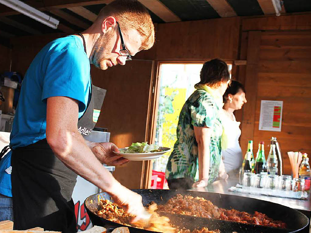 Alex Bndert brutzelt am Stand der Landfrauen und des Sportvereins Wittlekofen Gyros, zu dem leckerer Salat gereicht wird.