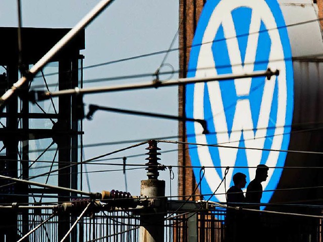 Die Silhouetten von zwei Mnnern auf e...Kraftwerk am VW Werk in Wolfsburg ab.   | Foto: dpa