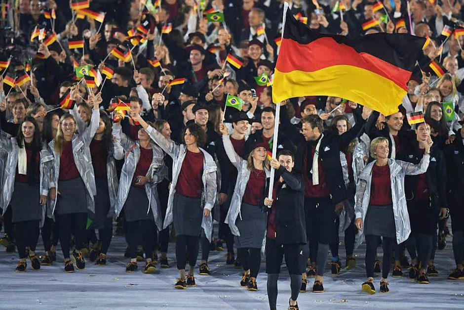 Die deutsche Mannschaft mit Fahnenträger Timo Boll genießt beim Einmarsch die Party-Stimmung im Maracanã-Stadion. (Foto: AFP) Die deutsche Mannschaft mit Fahnenträger Timo Boll genießt beim Einmarsch die Party-Stimmung im Maracanã-Stadion. (Foto: AFP)