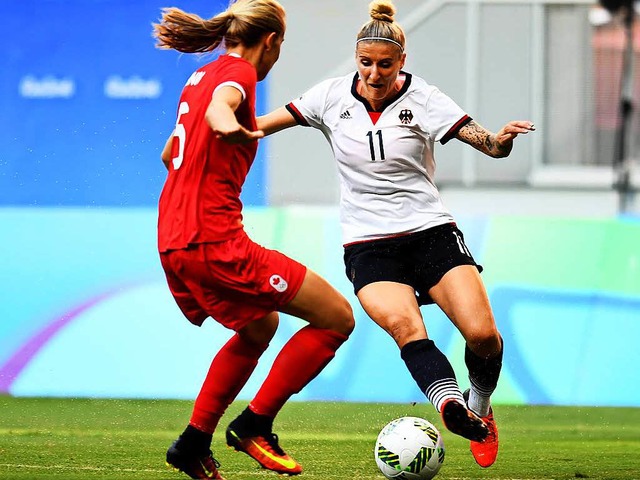 Die Spielerin Anja Mittag (rechts) im Duell gegen die Kanadierin Rebecca Quinn.  | Foto: AFP