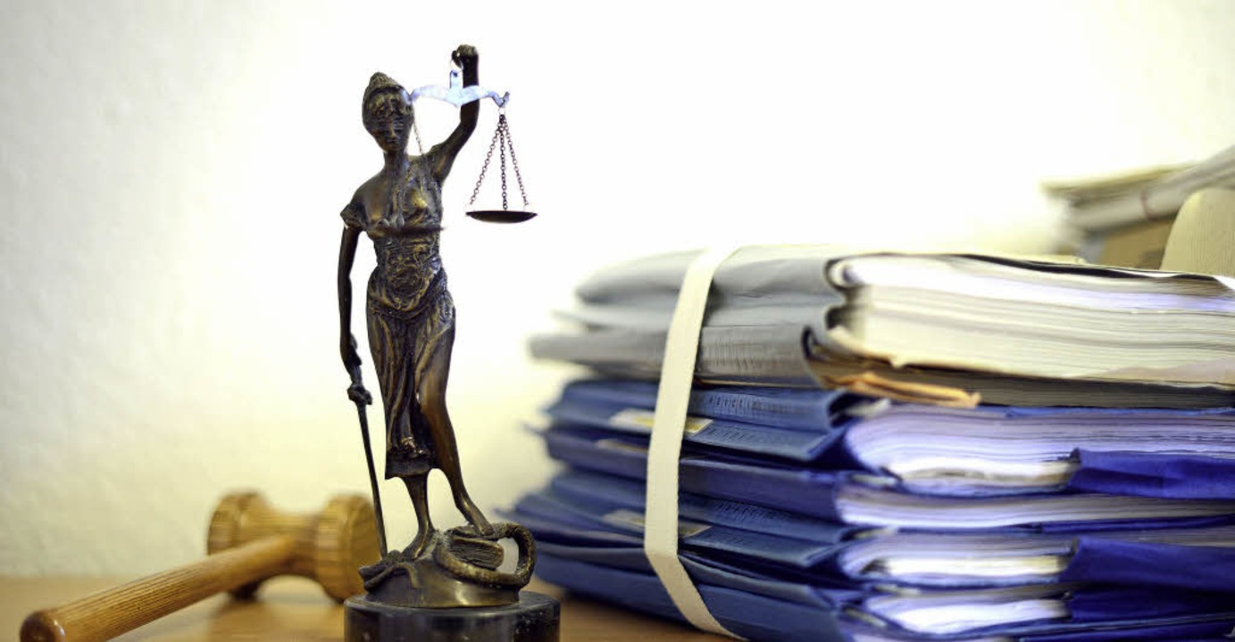 Die modellhafte Nachbildung der Justitia steht neben Akten.   | Foto: Dpa